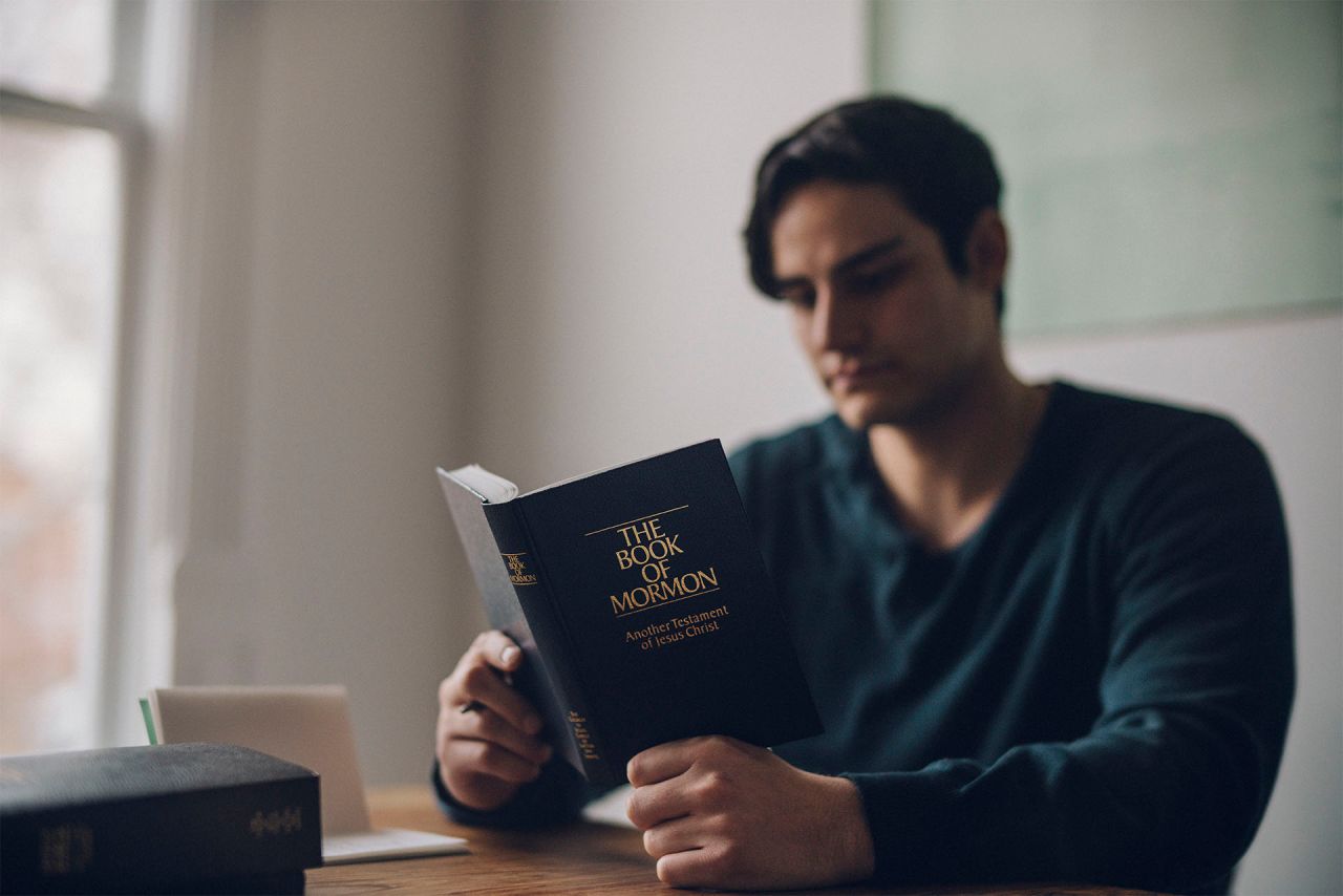 Чоловік читає Книгу Мормона